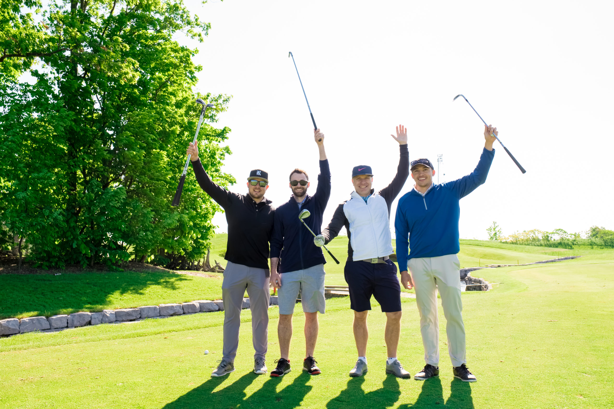 four men celebrating on the golf course